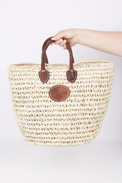 A model wearing size OneSize of the Oversize Round Open Weave Handle Basket in colour Natural, from the front, showing the whole outfit