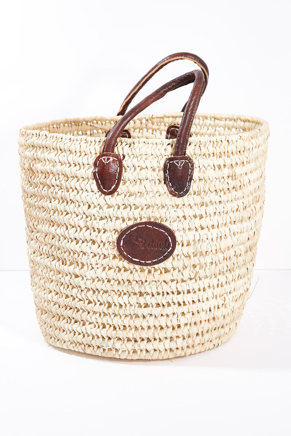 A model wearing size OneSize of the Oversize Round Open Weave Handle Basket in colour Natural, from the front, showing the whole outfit