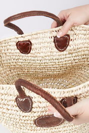A model wearing size OneSize of the Oversize Round Open Weave Handle Basket in colour Natural, from the front, showing the whole outfit