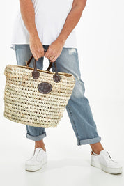 Model Sandy wearing size OneSize of the Oversize Round Open Weave Handle Basket in colour Natural, from the front, cropped image