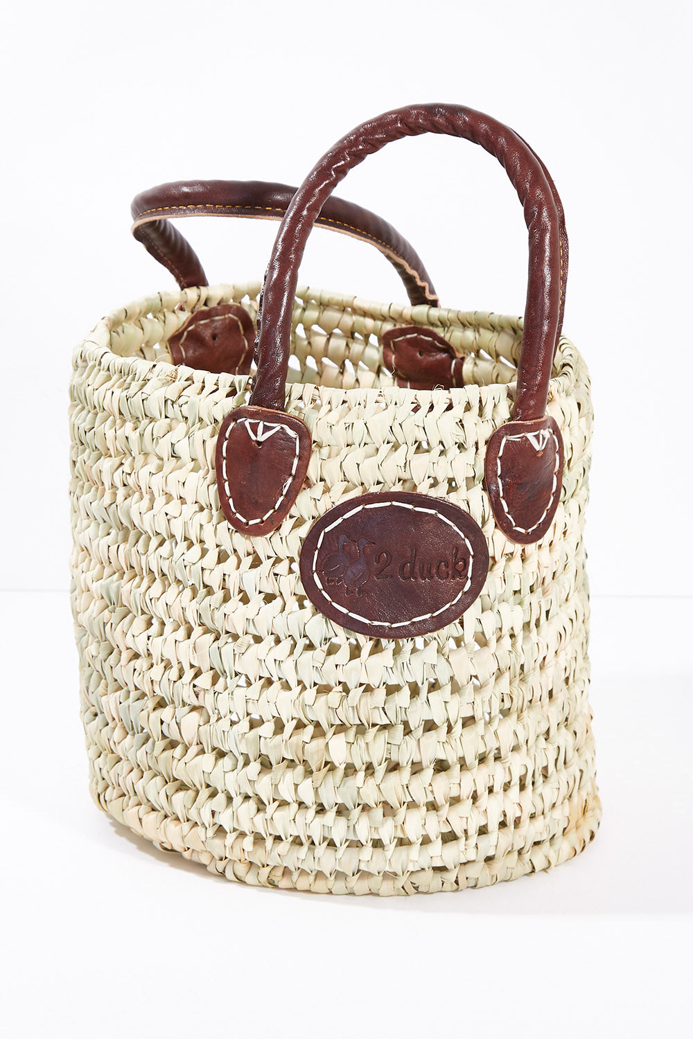 A model wearing size OneSize of the Small Round Open Weave Handle Basket in colour Natural, from the front, showing the whole outfit