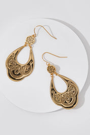A model wearing size OneSize of the Teardrop Engraved Drop Earrings in colour Gold (Metallics), from the front, showing the whole outfit