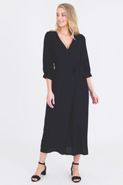 A model wearing the Eden Classic Wrap Dress in colour Navy (Blue), from the front, showing the whole outfit