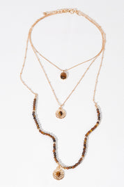 A model wearing size OneSize of the Trio Layers Medallion Long Necklace in colour Tangold, from the front, showing the whole outfit