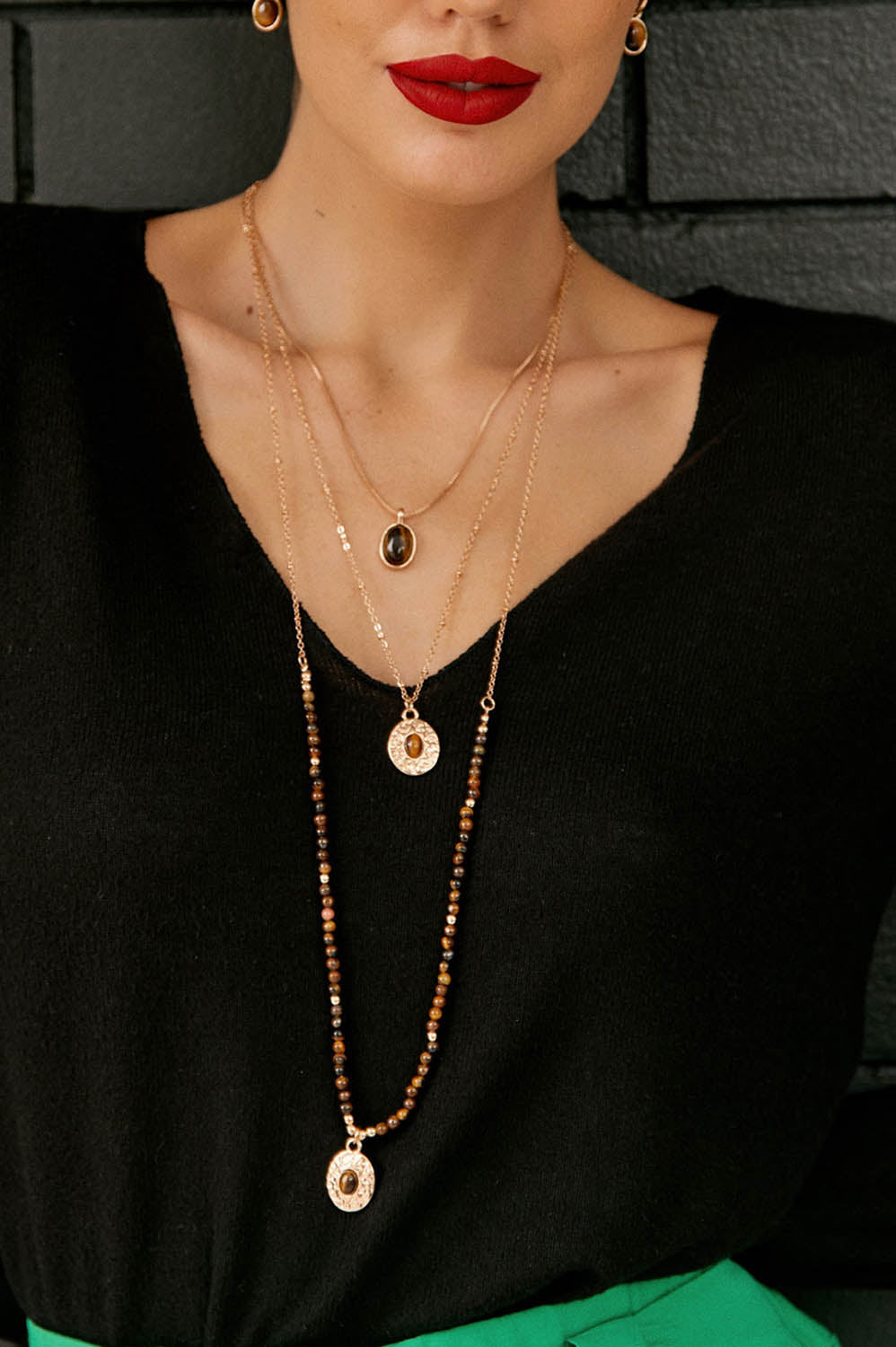 A model wearing the Trio Layers Medallion Long Necklace in colour Tangold, from the front, showing the whole outfit