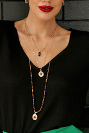 A model wearing the Trio Layers Medallion Long Necklace in colour Tangold, from the front, showing the whole outfit