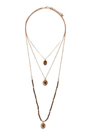 Product shot of the Trio Layers Medallion Long Necklace in colour Tangold, from the front