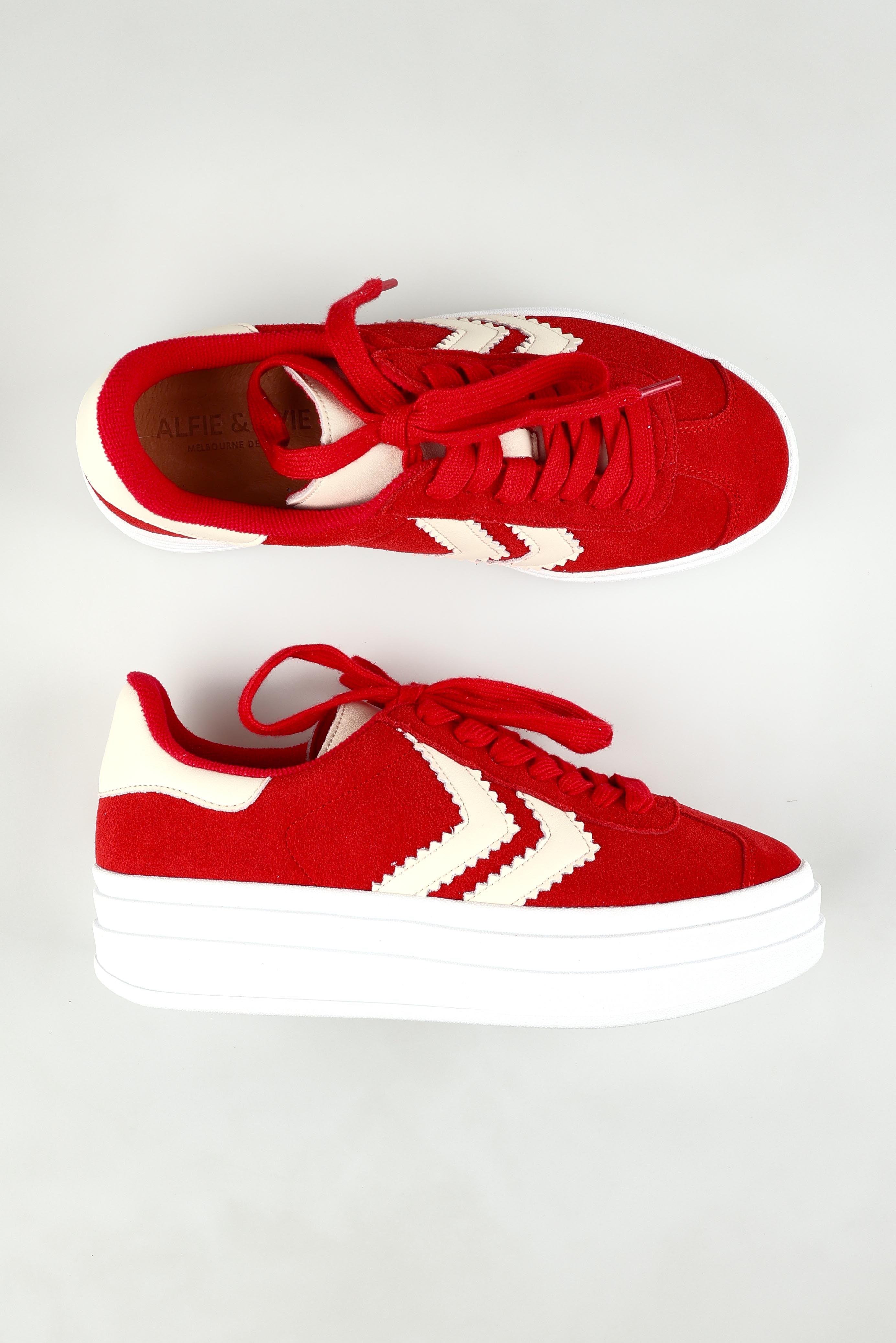 A model wearing size 37 of the Ignite Leather Sneaker in colour Redcream (Red), from the front, showing the whole outfit