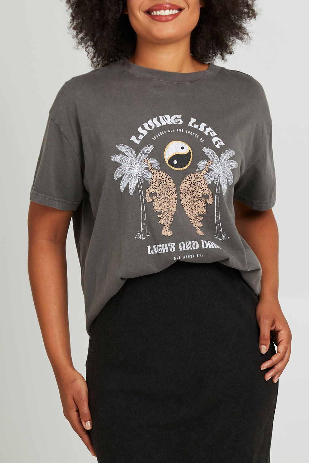Model Olivia wearing size 10 of the Living Life Standard Tee in colour Charcaol (Grey), from the front, cropped image