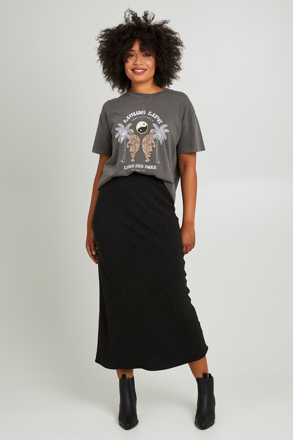 Model Olivia wearing size 10 of the Living Life Standard Tee in colour Charcaol (Grey), from the front, showing the whole outfit