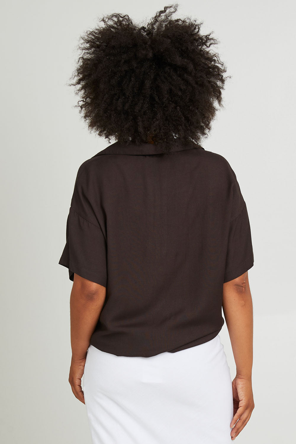 Model Olivia wearing size 10 of the Gracie Shirt in colour Back (Black), from the back