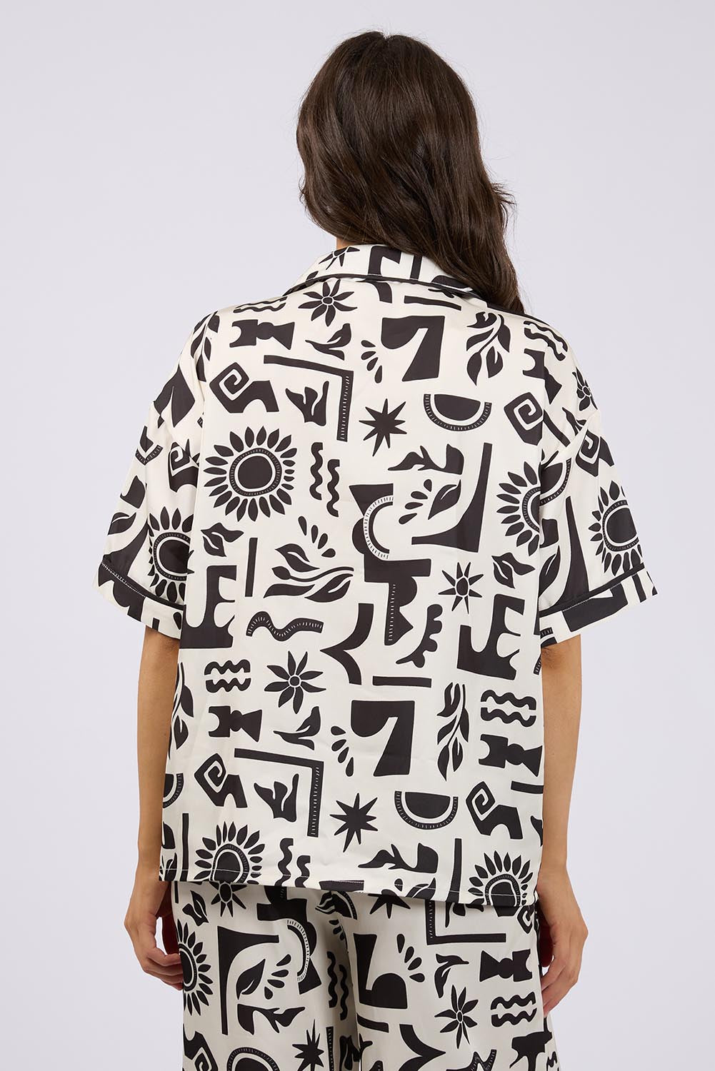 A model wearing the Array Button Up Shirt in colour Print (White), from the back