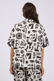 A model wearing the Array Button Up Shirt in colour Print (White), from the back