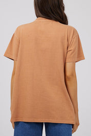 A model wearing the Baja Cotton Standard Tee in colour Tan, from the back