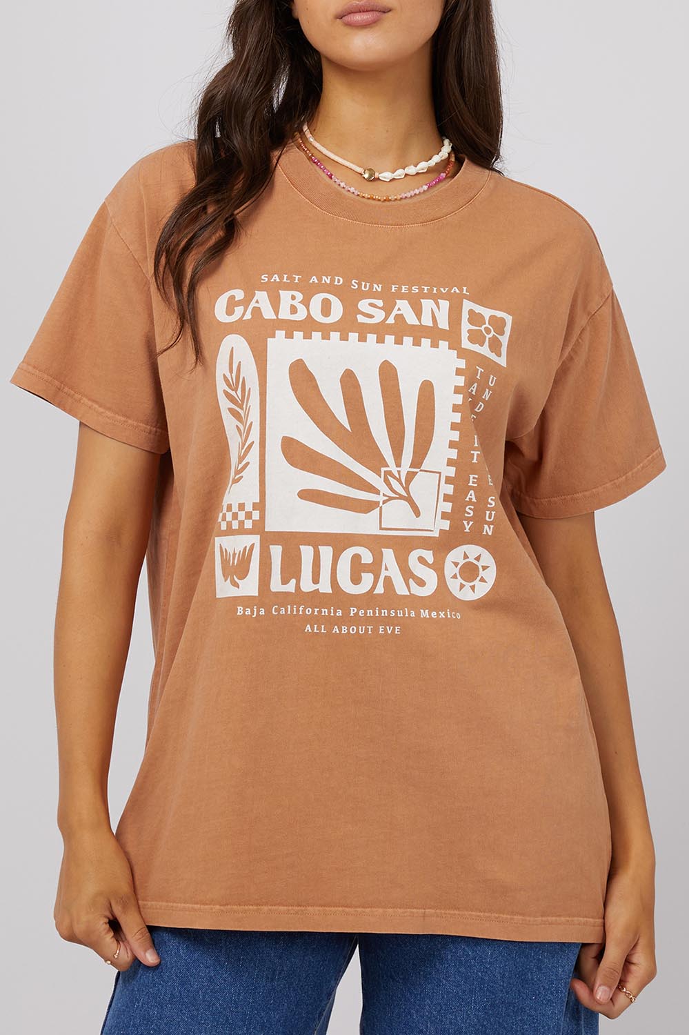 A model wearing the Baja Cotton Standard Tee in colour Tan, from the front, cropped image