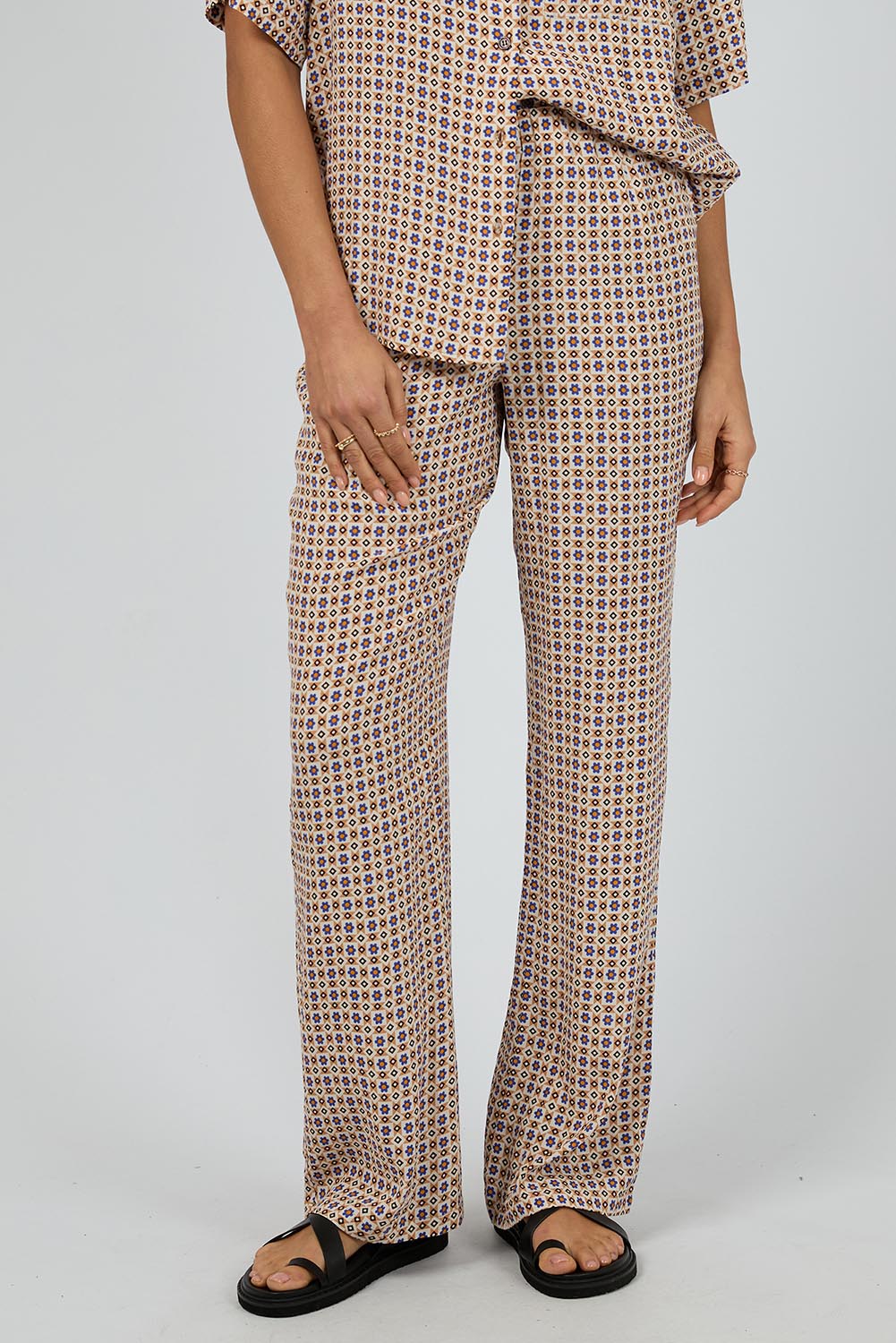 A model wearing the Harri Pants in colour Print, from the front, cropped image