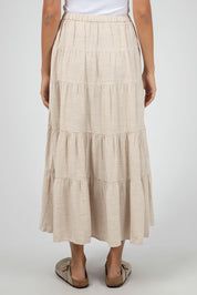 A model wearing the Hampton Maxi Skirt in colour Oat, from the back