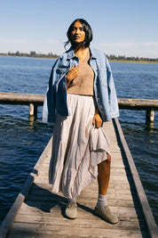 A model wearing the Hampton Maxi Skirt in colour Oat, from the front, showing the whole outfit