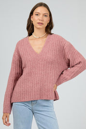 A model wearing the Clara Knit in colour Quartz (Pink), from the front, cropped image