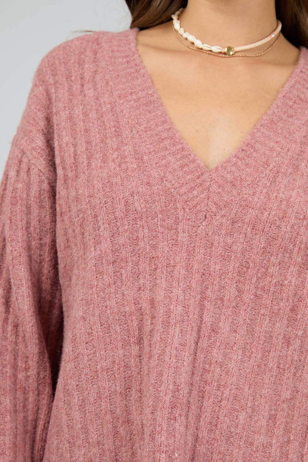 A model wearing the Clara Knit in colour Quartz (Pink), from the front, cropped image