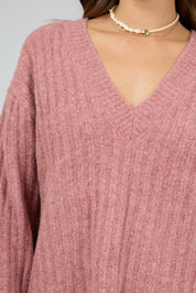 A model wearing the Clara Knit in colour Quartz (Pink), from the front, cropped image