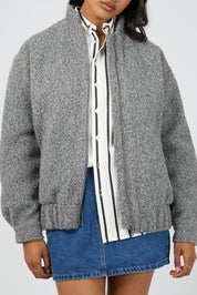 A model wearing the Tahlea Bomber Jacket in colour Greymarle (Grey), from the front, cropped image