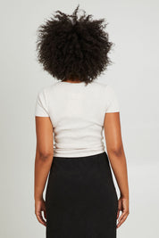 Model Olivia wearing size 10 of the Eve Rib Baby Tee in colour Oat, from the back
