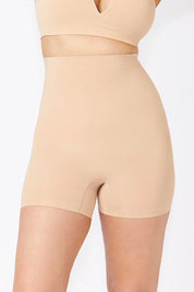 A model wearing the Powerlite High Waisted Short in colour Beige, from the front, cropped image