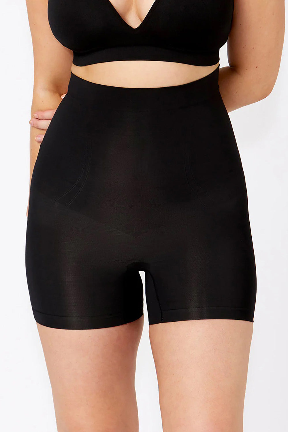 A model wearing the Powerlite High Waisted Short in colour Black, from the front, cropped image