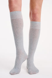 A model wearing the Organic Cotton Cable Knit Knee High Socks in colour Greymarle (Grey), from the front, cropped image