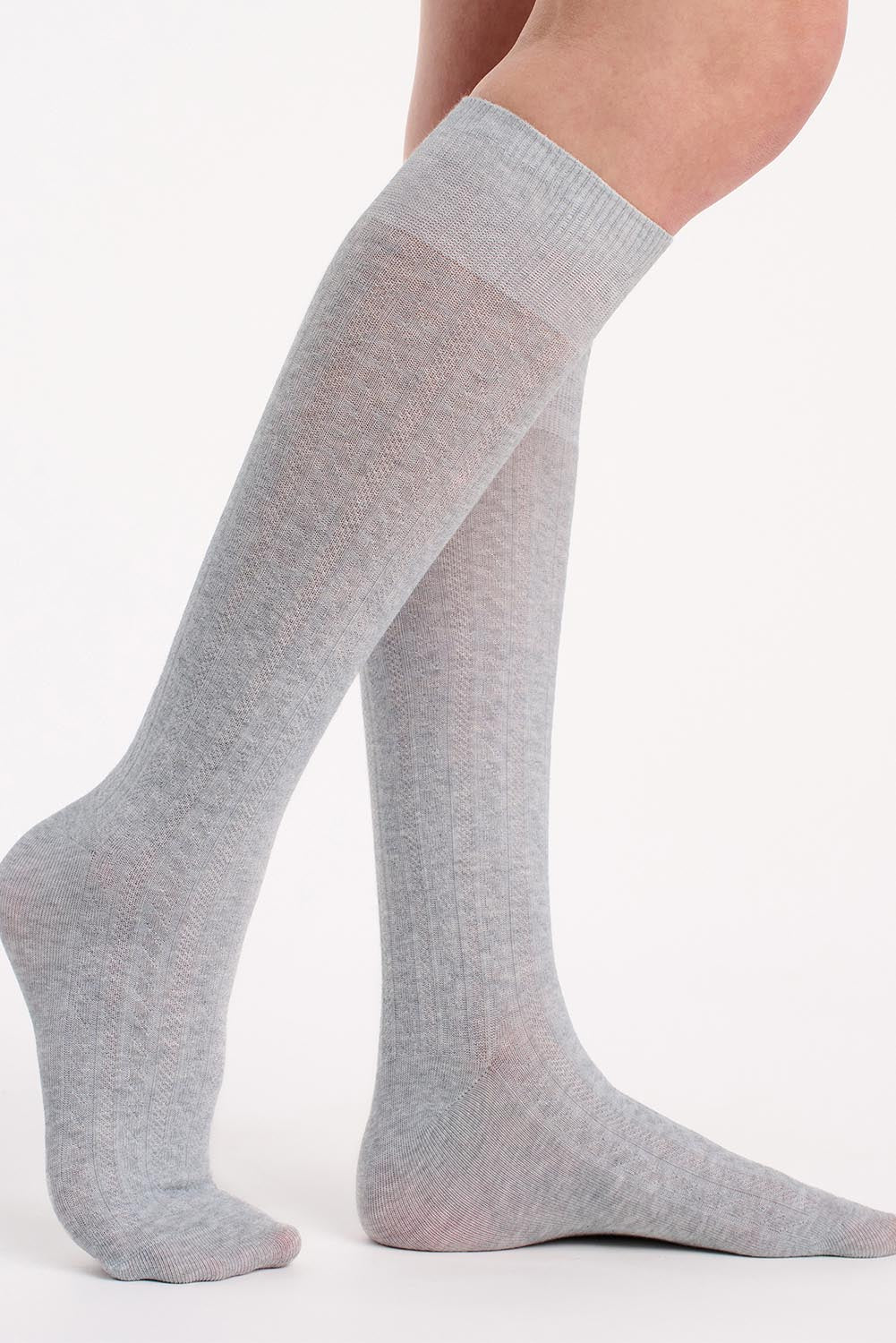 A model wearing the Organic Cotton Cable Knit Knee High Socks in colour Greymarle (Grey), from the front, cropped image