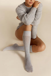 A model wearing the Organic Cotton Cable Knit Knee High Socks in colour Greymarle (Grey), from the front, showing the whole outfit