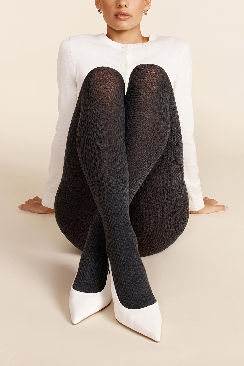 A model wearing the Textured Knit Tights in colour Charcoal (Grey), from the front, showing the whole outfit