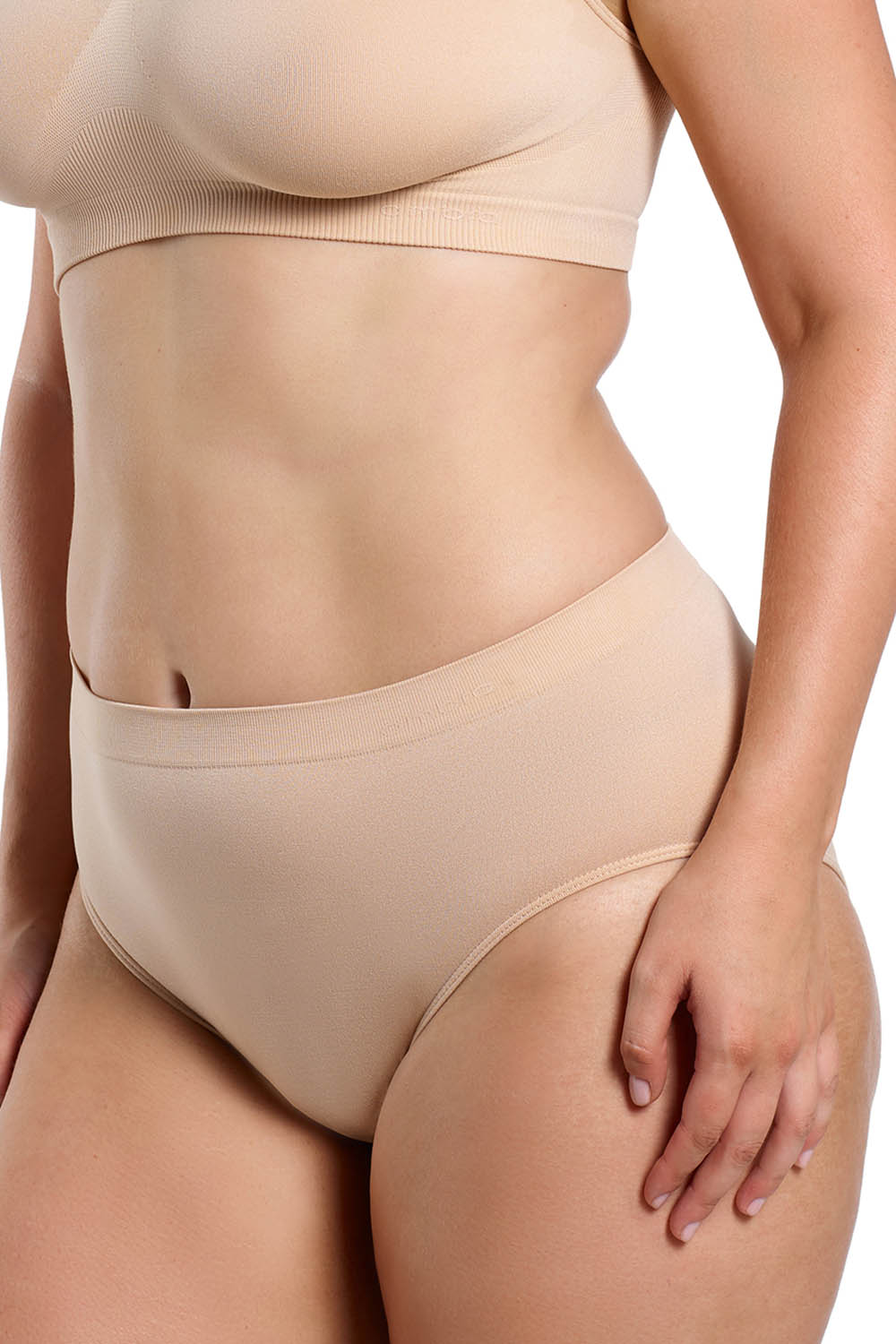 A model wearing the Curvesque Hi Cut in colour Nude, from the front, cropped image