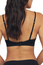 A model wearing the Bare Essentials Moulded Wirefree Bra in colour Black (Black), from the back