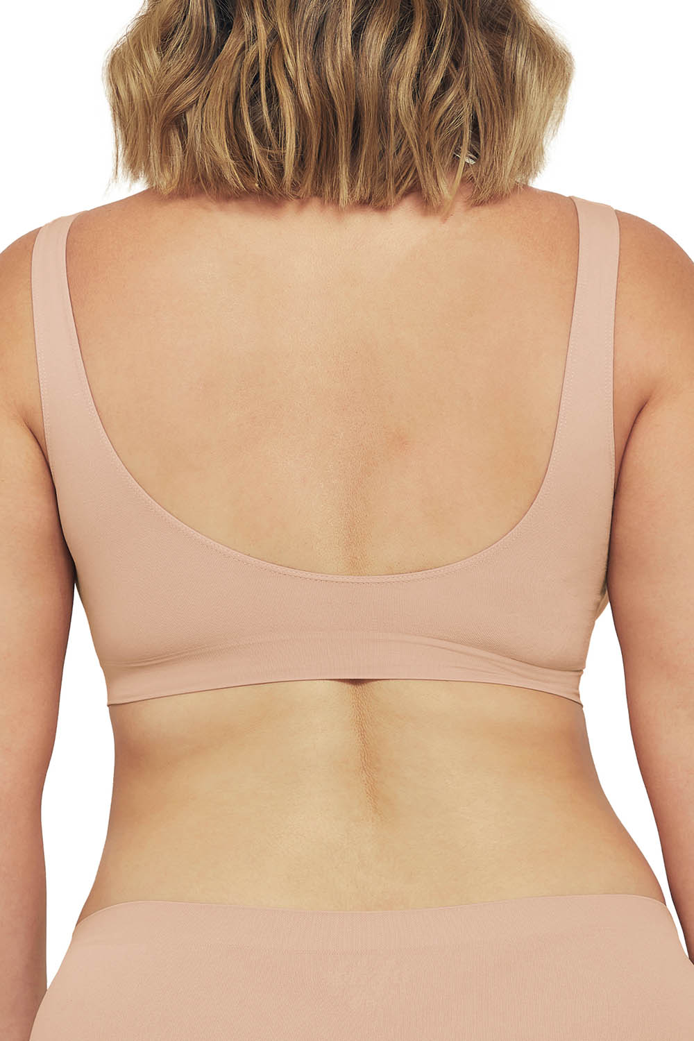 A model wearing the Bare Essentials Shaper Bra in colour Rosebeige, from the back
