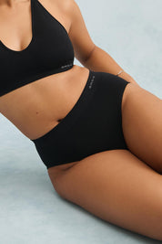 A model wearing the Pure Basics Modal Midi Briefs 2 Pack in colour Black (Black), from the front, cropped image