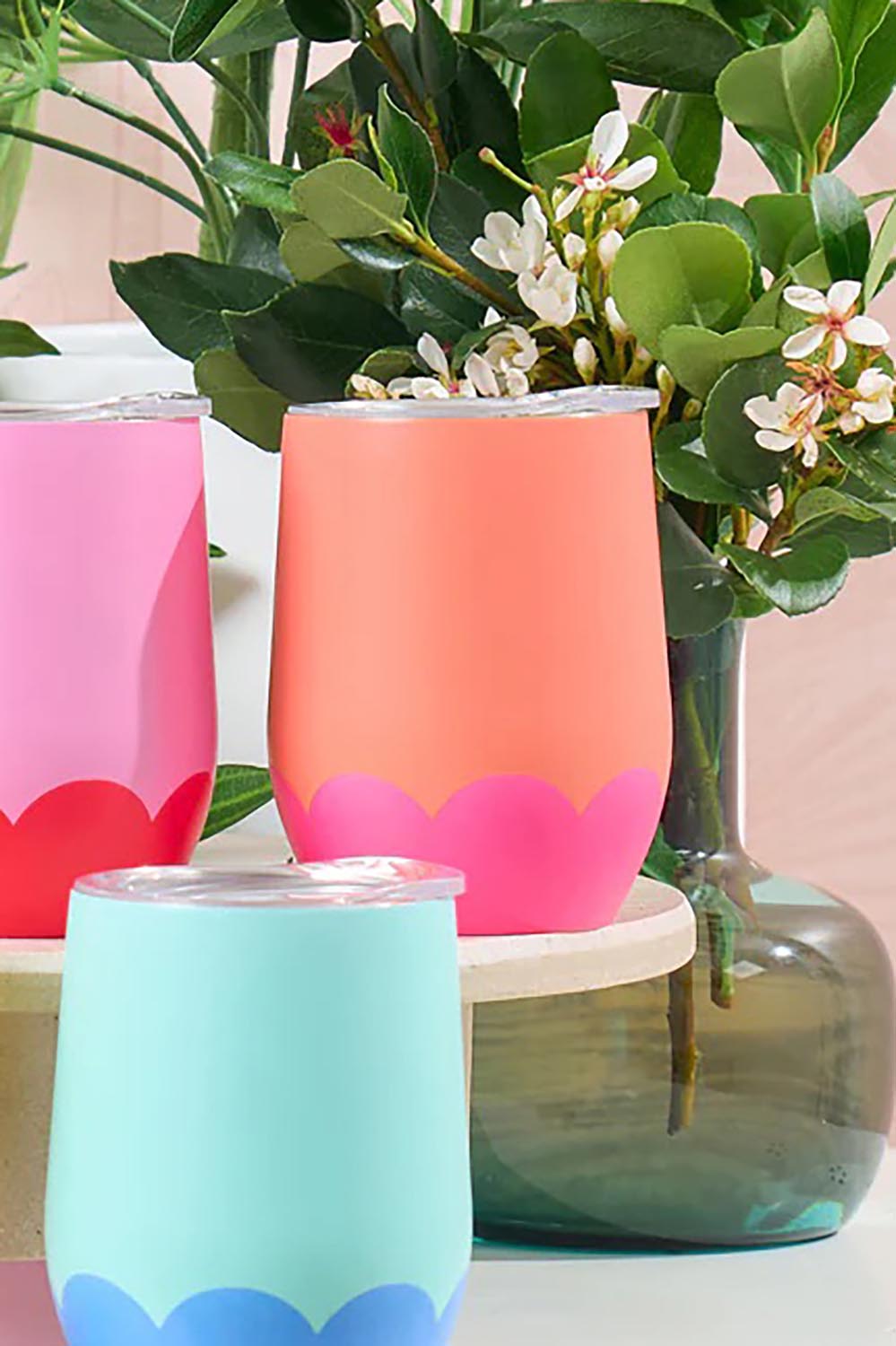 A model wearing the Stainless Steel 350Ml Wine Tumbler in colour Orangepink, from the front, showing the whole outfit
