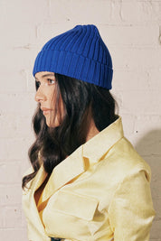 A model wearing the Tucker Merino Wool Beanie in colour Royal (Blue), from the front, showing the whole outfit