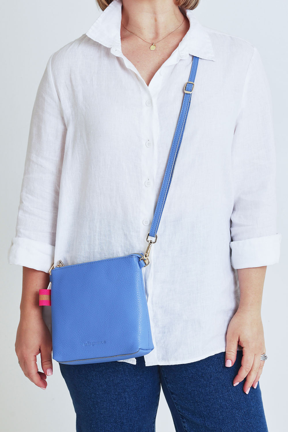 Model Steph wearing size OneSize of the Alexis Leather Crossbody in colour Cornflower (Blue), from the front, cropped image