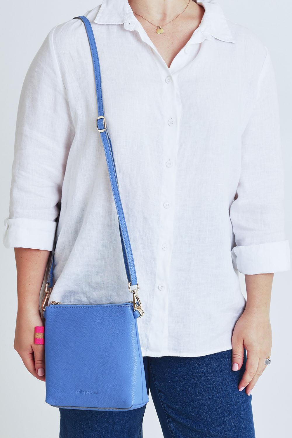 Model Steph wearing size OneSize of the Alexis Leather Crossbody in colour Cornflower (Blue), from the front, cropped image