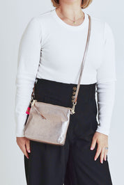 Model Steph wearing size OneSize of the Alexis Leather Crossbody in colour Gold (Metallics), from the front, cropped image