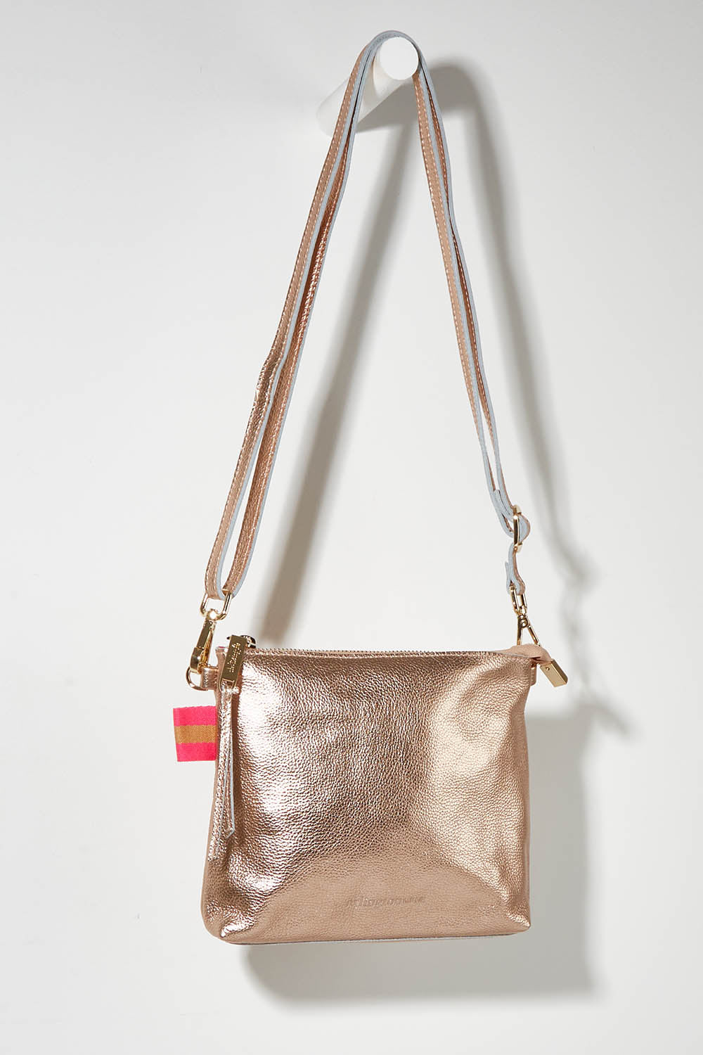 A model wearing size OneSize of the Alexis Leather Crossbody in colour Rosegold (Metallics), from the front, showing the whole outfit