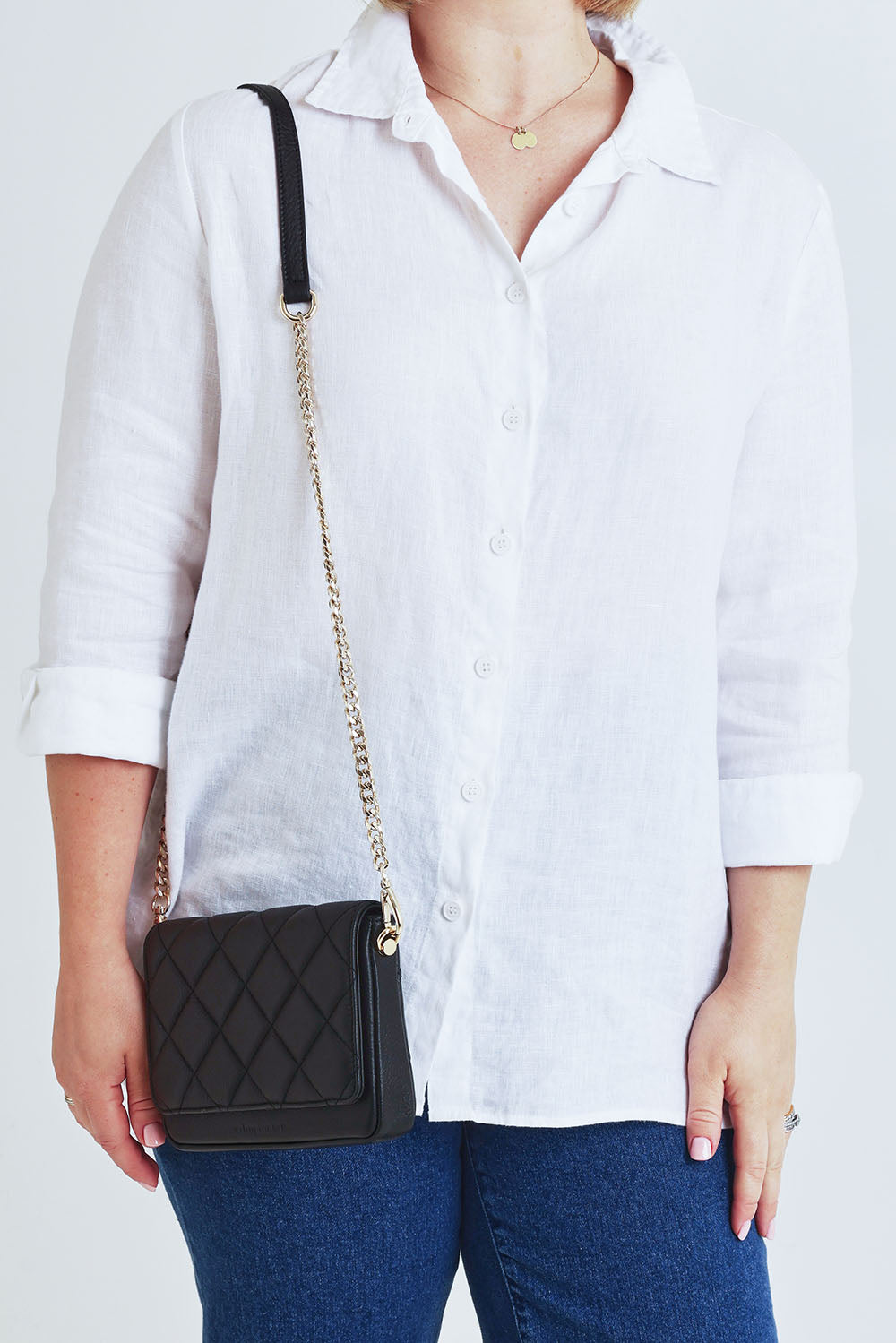 Model Steph wearing the Sarah Leather Quilted Crossbody in colour Black (Black), from the front, cropped image