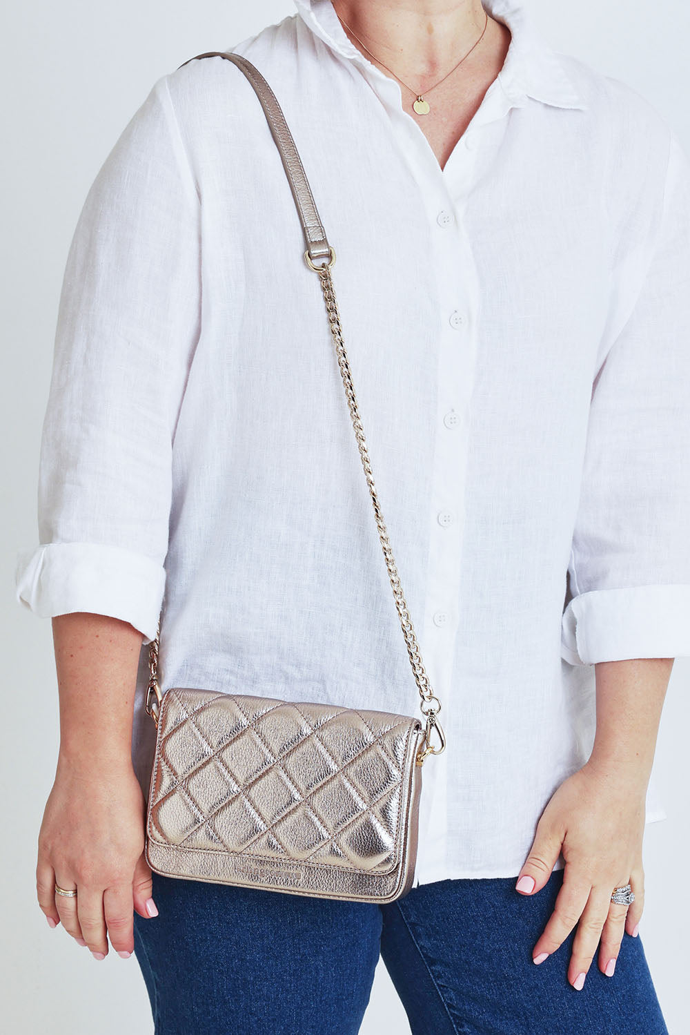 Model Steph wearing the Sarah Leather Quilted Crossbody in colour Gold (Metallics), from the front, cropped image