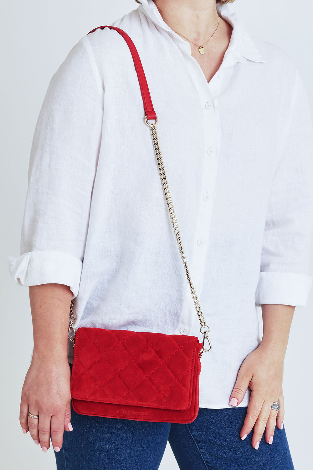 Model Steph wearing the Sarah Leather Quilted Crossbody in colour Redsuede (Red), from the front, cropped image