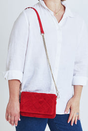 Model Steph wearing the Sarah Leather Quilted Crossbody in colour Redsuede (Red), from the front, cropped image