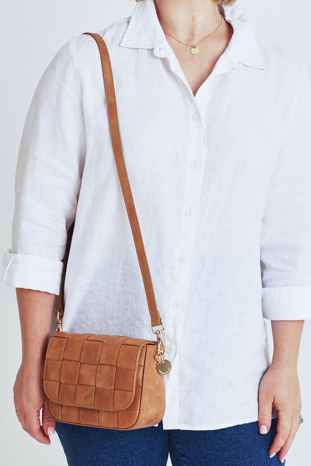 Model Steph wearing size OneSize of the Clara Weave Leather Crossbody in colour Vinagetan, from the front, cropped image