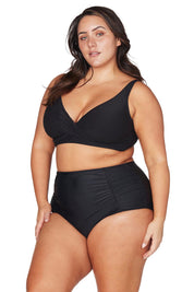 A model wearing the Raphael High Waist Ruched Swim Pant in colour Black (Black), from the front, cropped image