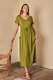 A model wearing the Mila Maxi Dress in colour Cardamom (Green), from the front, showing the whole outfit